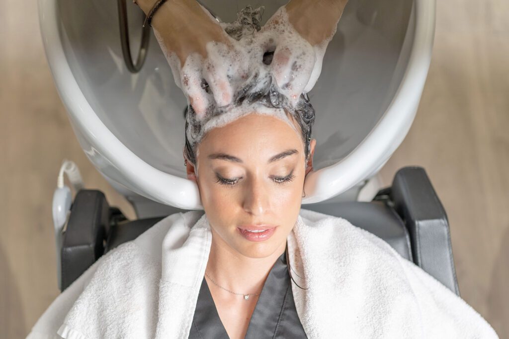 Una peluquera de CIM Perruquers lavando el pelo de una clienta