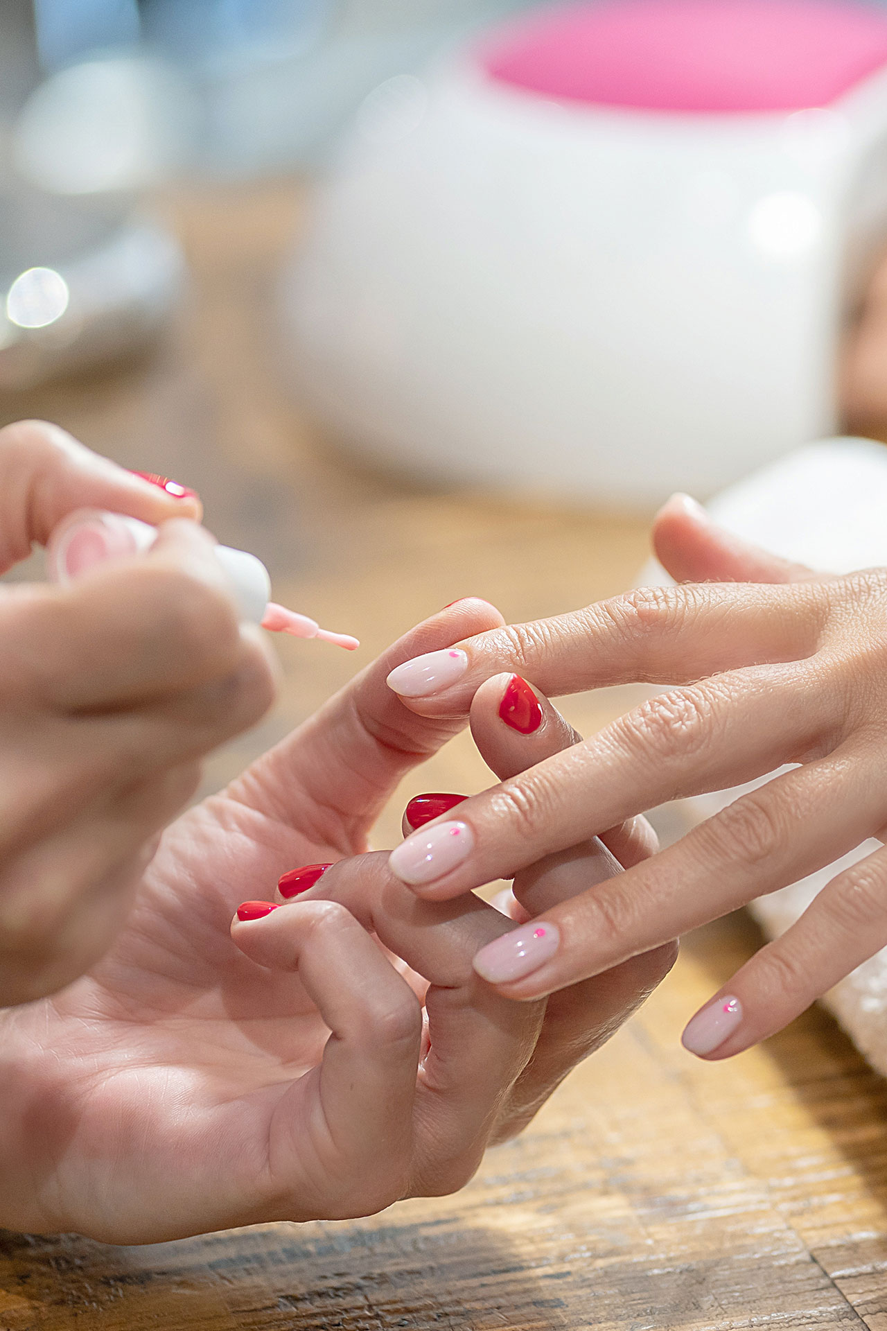 Una trabajadora de CIM Perruquers pinta las uñas de una clienta